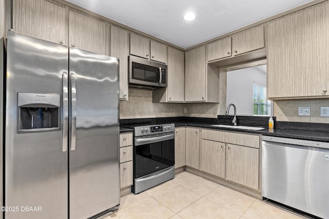 kitchen with light brown cabinets, appliances with stainless steel finishes, sink, backsplash, and light tile patterned flooring