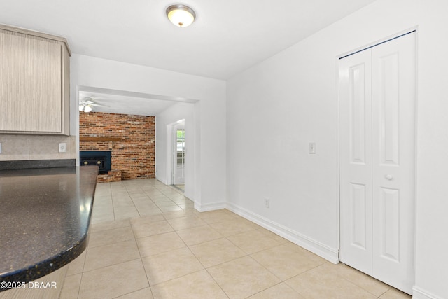 interior space featuring light brown cabinets, light tile patterned floors, and a wood stove