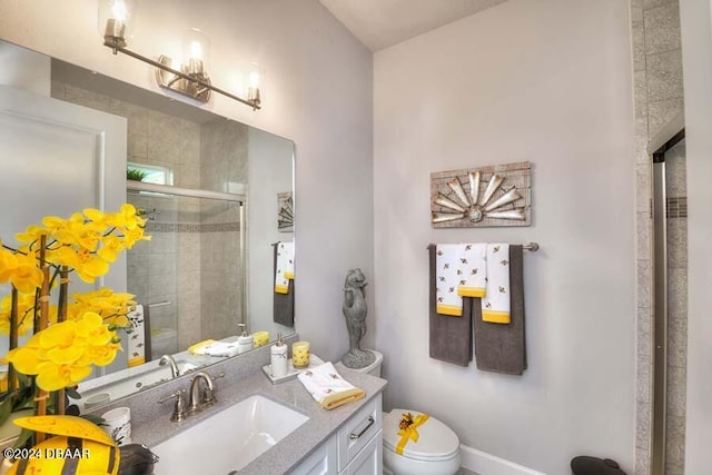 bathroom with a shower with door, vanity, and toilet