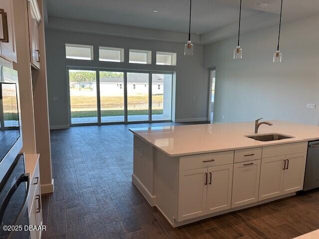 kitchen featuring white cabinetry, sink, pendant lighting, and dishwasher