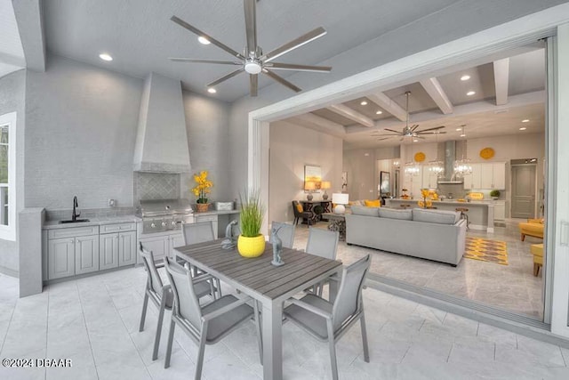 dining space featuring beamed ceiling, ceiling fan, and sink