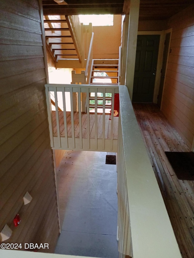 stairway with a wealth of natural light and wooden walls