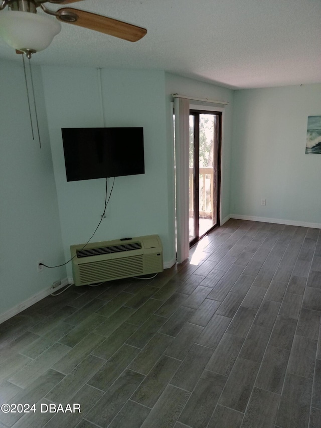 unfurnished living room featuring a textured ceiling, dark hardwood / wood-style flooring, ceiling fan, and a wall mounted air conditioner