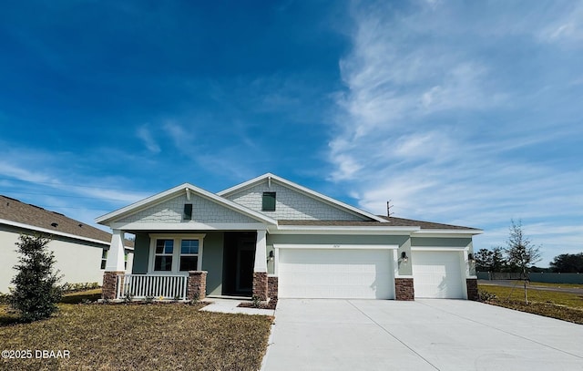 craftsman inspired home featuring stucco siding, stone siding, a porch, concrete driveway, and a garage