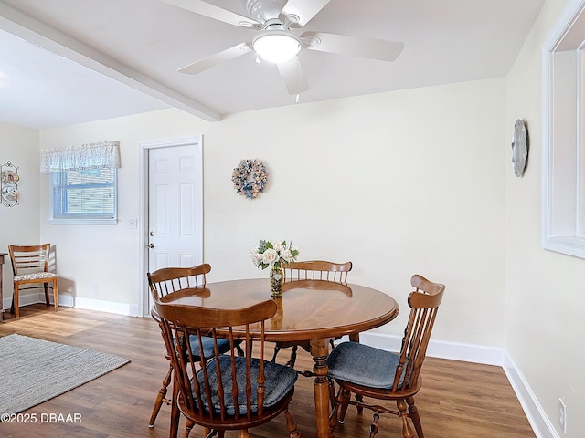 dining area with ceiling fan, beamed ceiling, wood finished floors, and baseboards