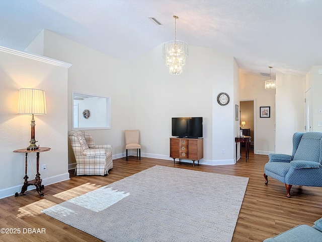 living room with wood finished floors, visible vents, and an inviting chandelier