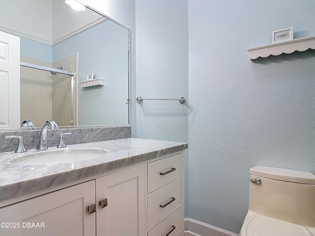 full bath with a textured wall, vanity, and toilet