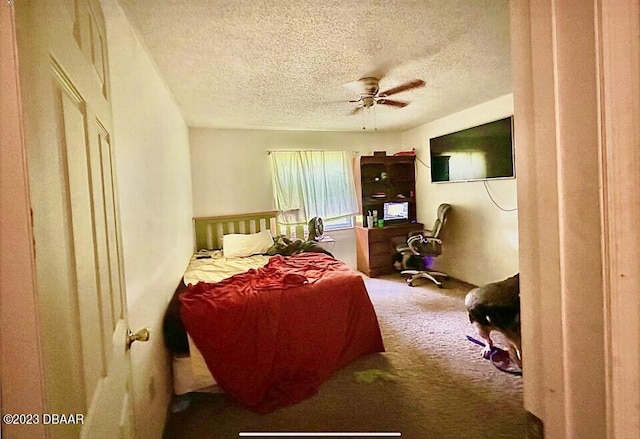 bedroom with a textured ceiling, carpet, and ceiling fan