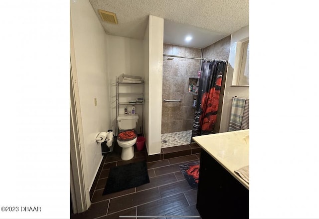 bathroom with a shower with curtain, vanity, and a textured ceiling