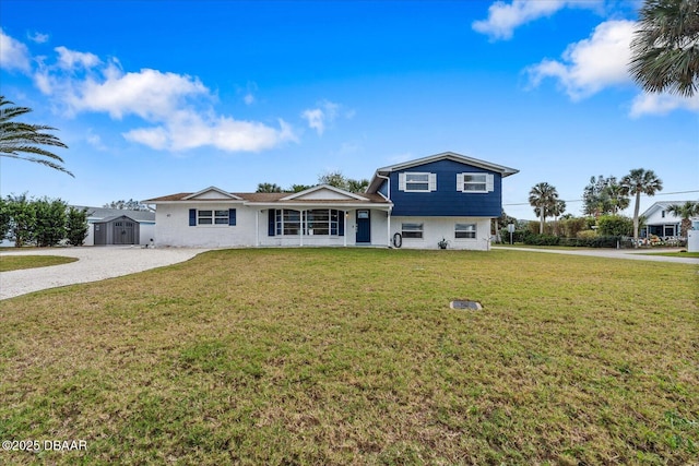 view of front of home featuring a storage shed, a front lawn, decorative driveway, and an outdoor structure