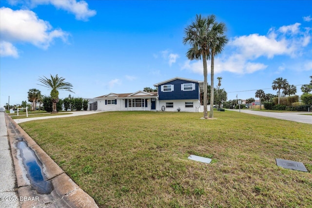 view of front of property featuring concrete driveway and a front yard