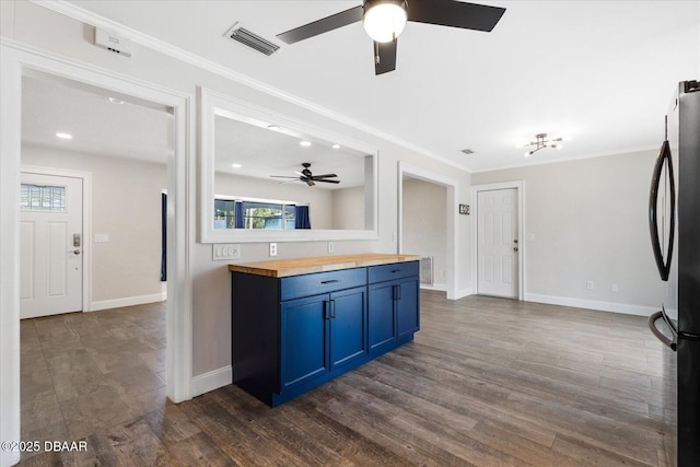 kitchen with visible vents, butcher block countertops, ornamental molding, dark wood-type flooring, and freestanding refrigerator