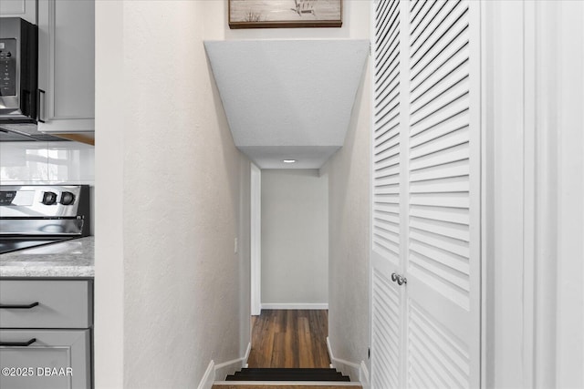 stairway featuring baseboards and wood finished floors