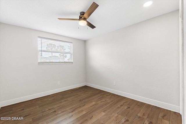 empty room with ceiling fan, baseboards, and wood finished floors