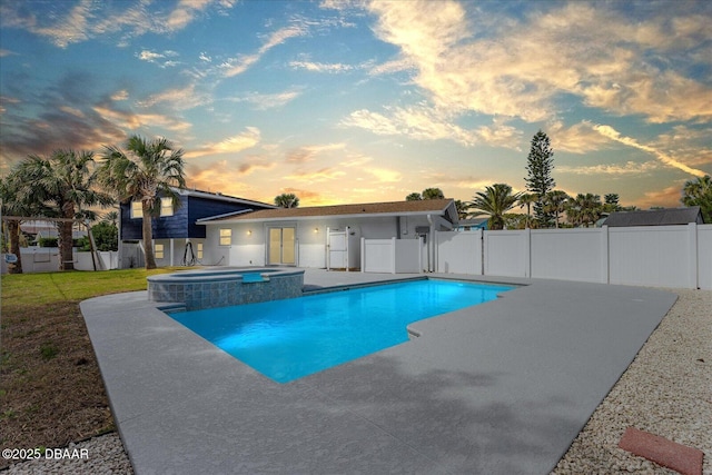 view of pool featuring a patio, a yard, fence, and a pool with connected hot tub