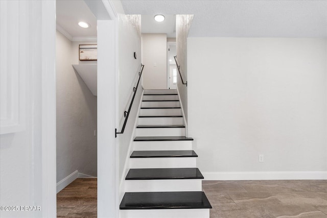 stairway with a textured ceiling and baseboards