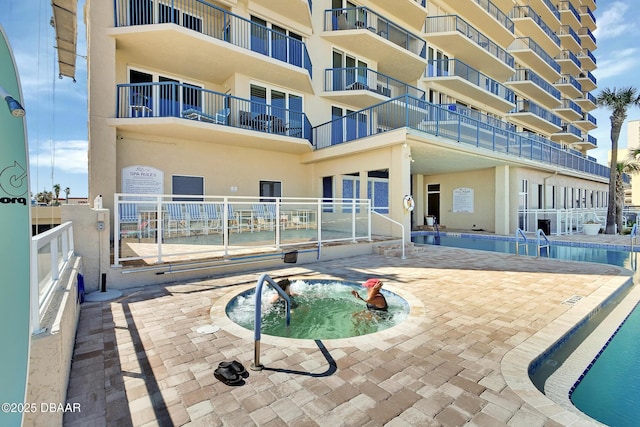 pool featuring a patio area and a community hot tub