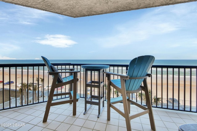 balcony featuring a view of the beach and a water view