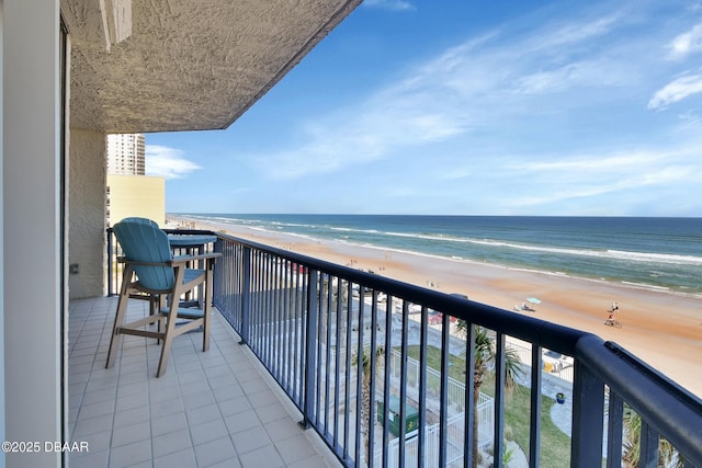 balcony featuring a beach view and a water view