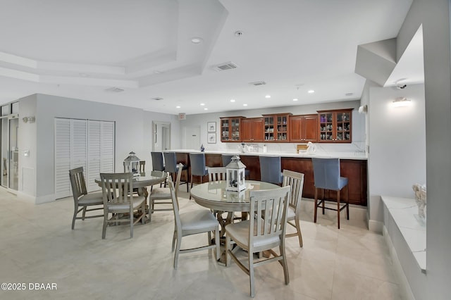 dining room with visible vents, recessed lighting, a raised ceiling, and baseboards