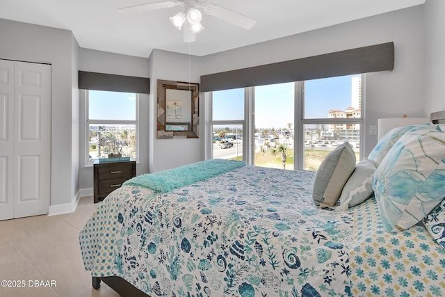 bedroom featuring baseboards, ceiling fan, and light tile patterned flooring