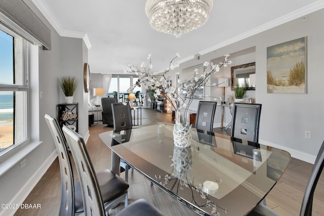 dining space featuring ornamental molding, wood finished floors, baseboards, and a chandelier