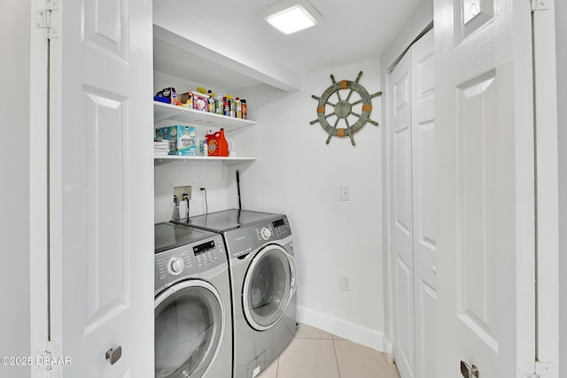 laundry room featuring light tile patterned floors, baseboards, laundry area, washer and clothes dryer, and indoor bar