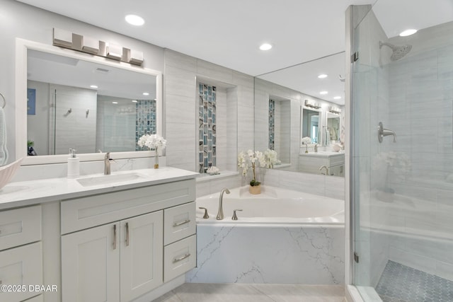 bathroom featuring a bath, recessed lighting, a stall shower, and vanity