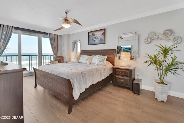 bedroom featuring baseboards, a water view, ornamental molding, light wood-style floors, and access to outside