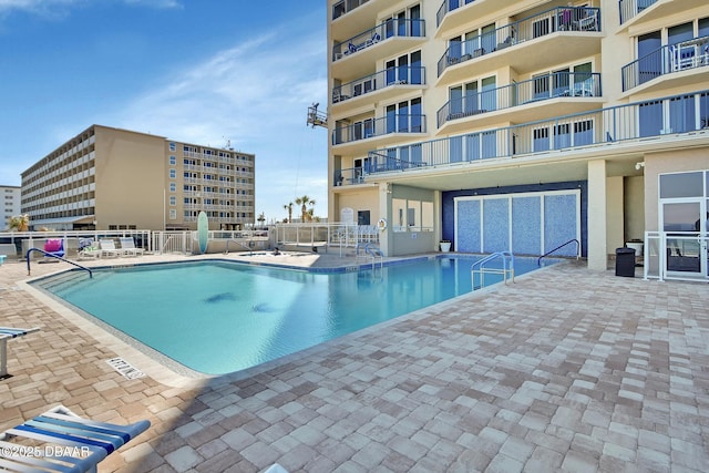 community pool featuring fence and a patio area