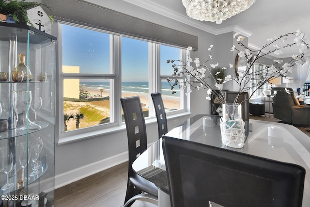 dining area with baseboards, wood finished floors, an inviting chandelier, and ornamental molding