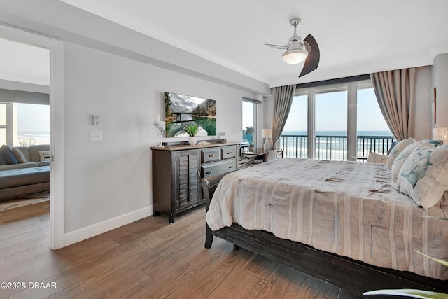 bedroom with access to outside, multiple windows, a water view, and ornamental molding