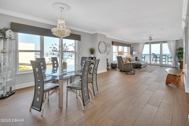 dining space featuring wood finish floors, baseboards, a notable chandelier, and ornamental molding