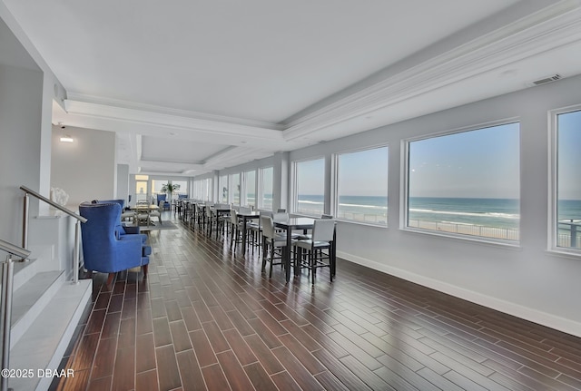 dining room featuring visible vents, a water view, baseboards, and wood tiled floor