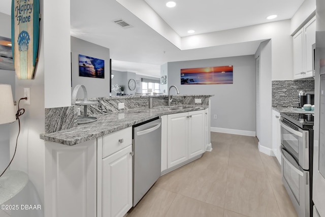 kitchen with visible vents, a sink, tasteful backsplash, white cabinetry, and stainless steel appliances