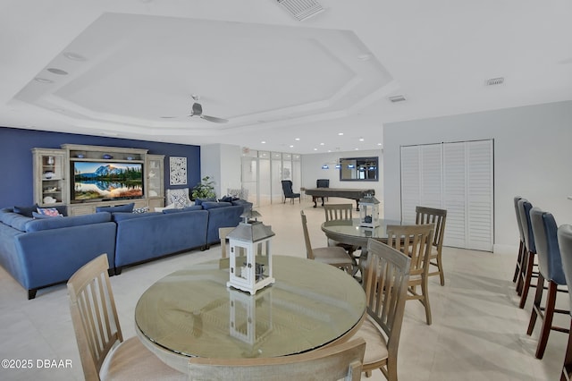 dining space with visible vents, a raised ceiling, and a ceiling fan