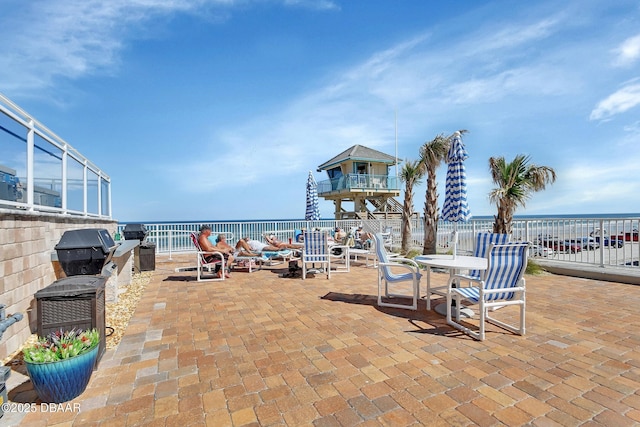 view of patio featuring area for grilling, outdoor dining area, and a water view