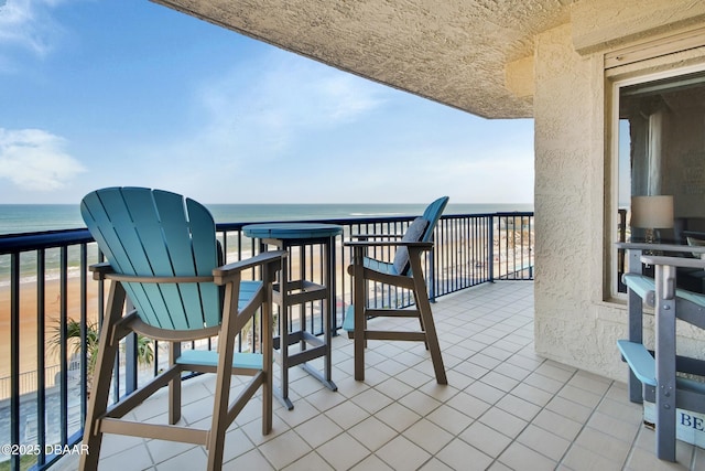 balcony with a water view and a beach view