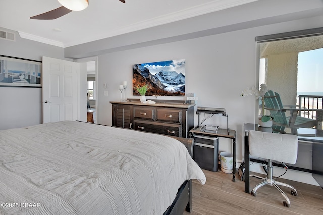 bedroom featuring multiple windows, wood finished floors, visible vents, and ornamental molding