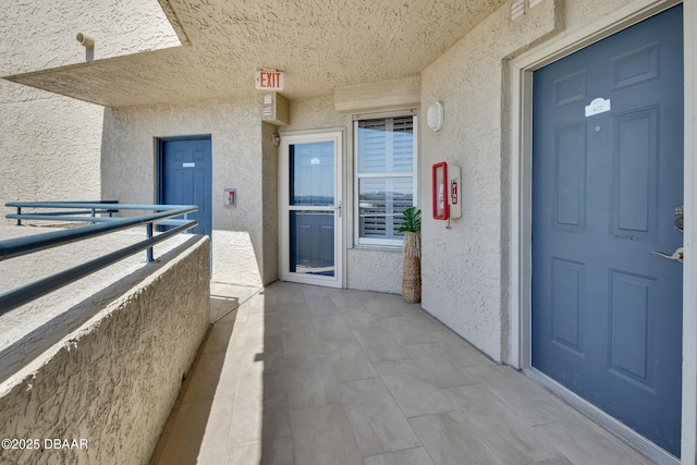 entrance to property featuring stucco siding