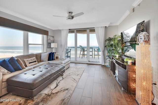 living area with visible vents, a water view, wood finished floors, crown molding, and ceiling fan