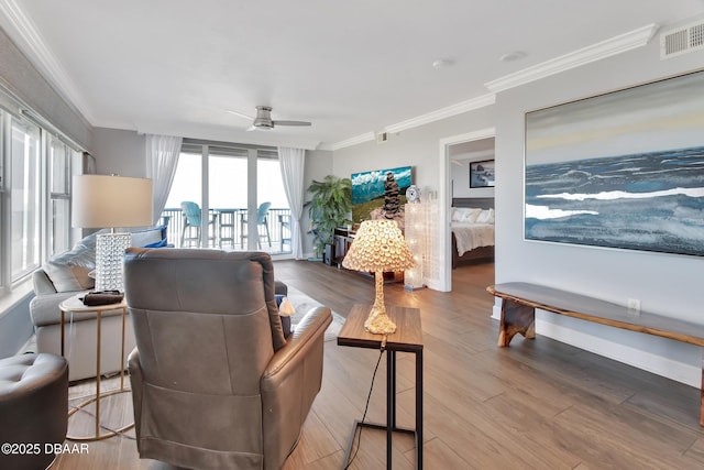 living room with visible vents, crown molding, baseboards, wood finished floors, and a ceiling fan