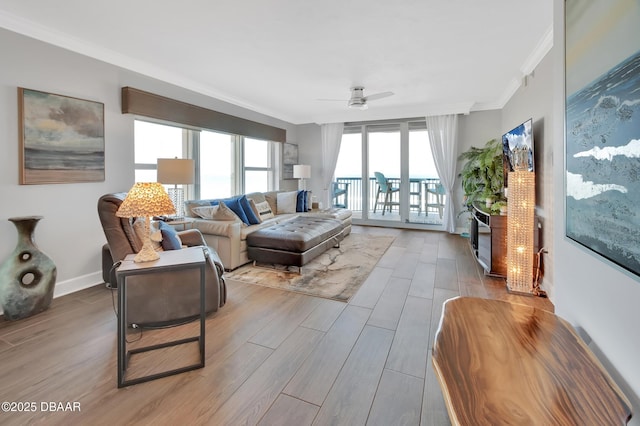 living area featuring ceiling fan, baseboards, wood finished floors, and ornamental molding