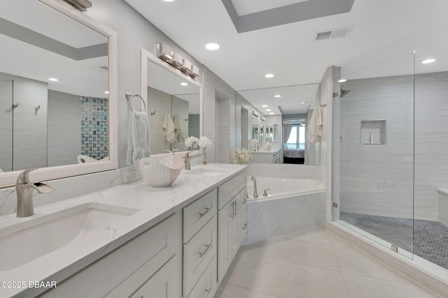 full bath with visible vents, a stall shower, and a sink