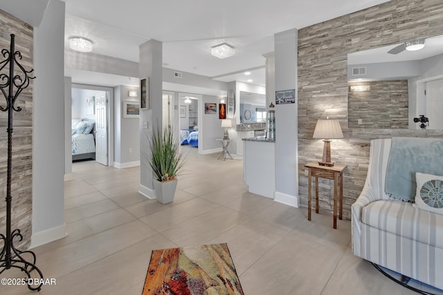 living area with light tile patterned floors, baseboards, and visible vents