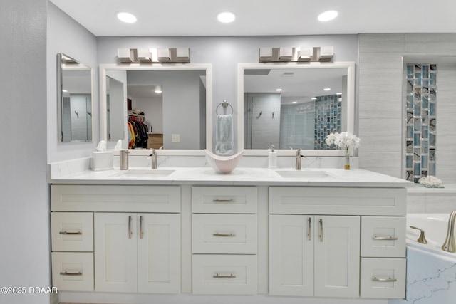 full bath with a shower stall, double vanity, and a sink