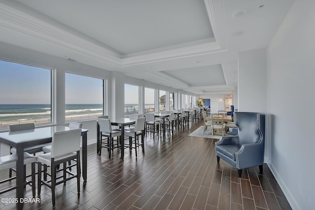 dining space featuring wood finish floors, a tray ceiling, and ornamental molding