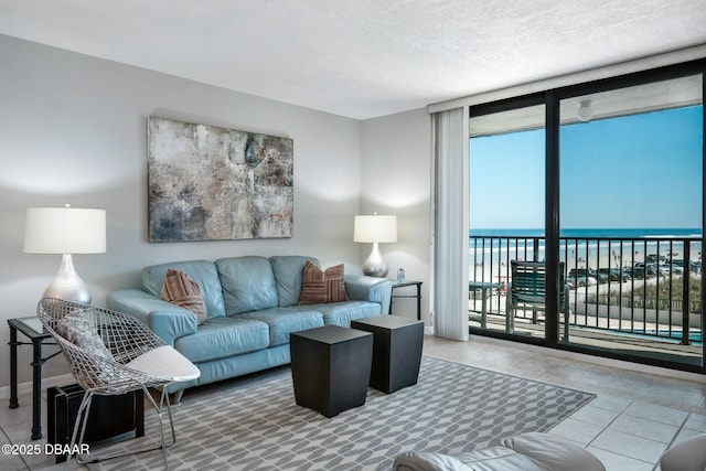 tiled living room with a water view, expansive windows, and a textured ceiling