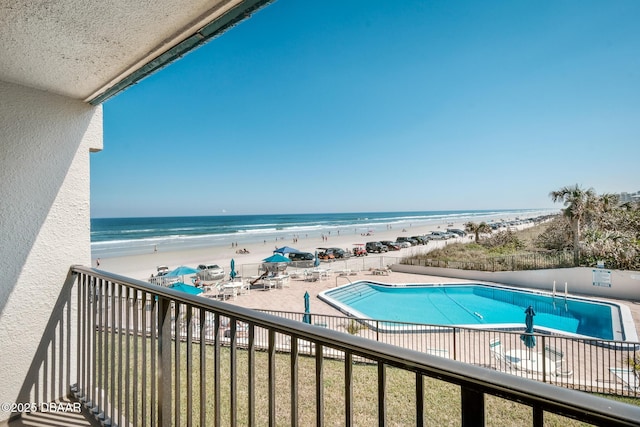 balcony featuring a patio area, a water view, and a view of the beach