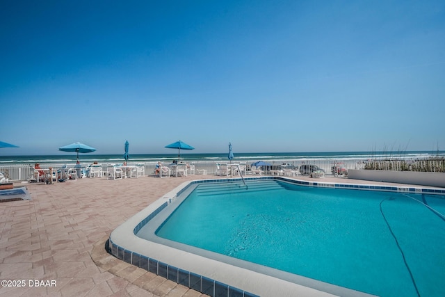 community pool with a water view and a patio